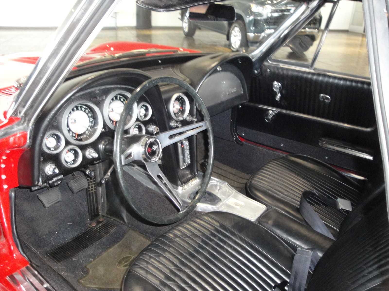Interior en cuero negro del Corvette Sting Ray 1963 desde la puerta del conductor