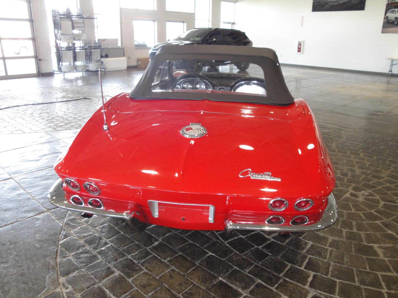 Corvette Sting Ray 1963 rojo, vista trasera con ópticas dobles y emblema Corvette