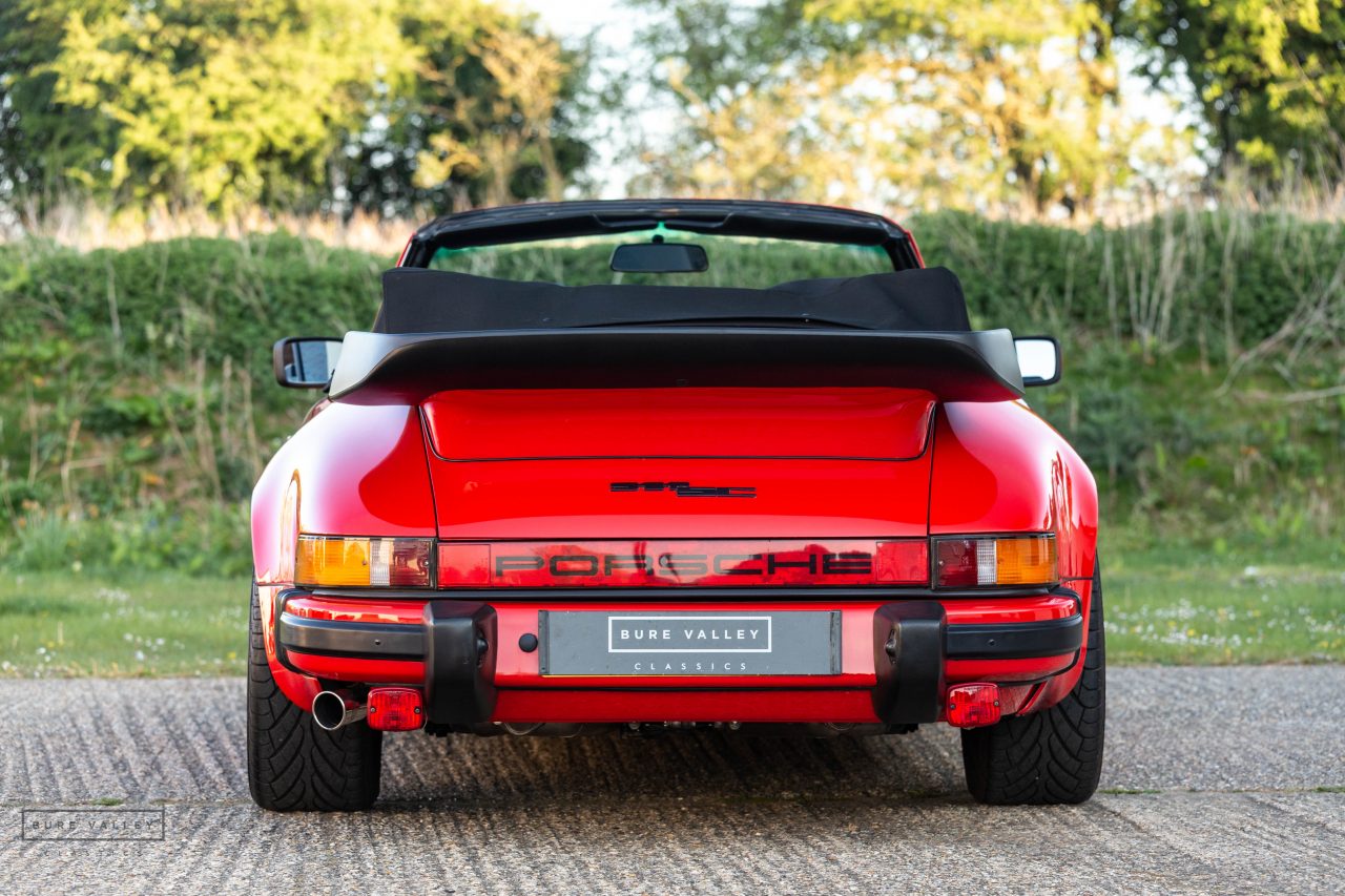 Porsche 911 SC Cabriolet 1983 rojo, vista trasera con alerón y salida de escape