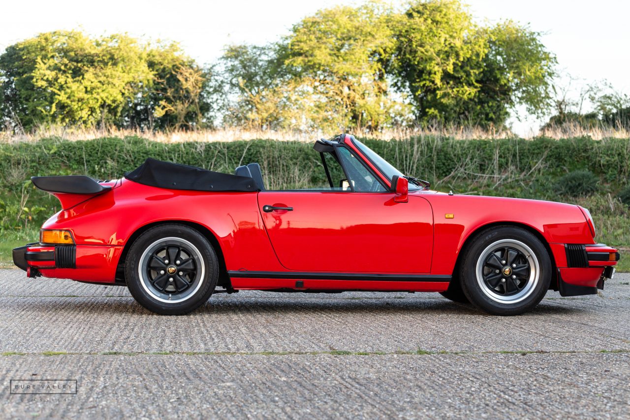 Porsche 911 SC Cabriolet 1983 rojo, perfil lateral izquierdo con alerón trasero